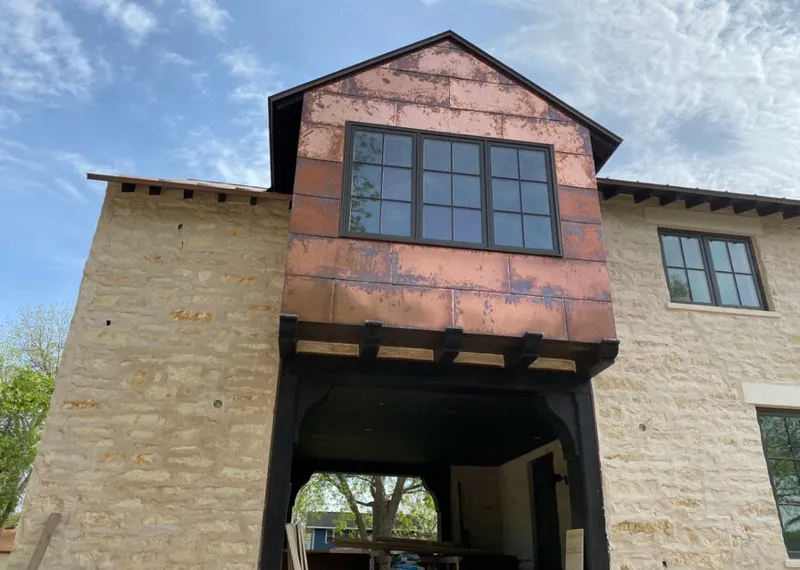 Copper metal panel facade on a stone building for Skylight Installation in Edgewater